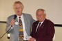 David Janes presents DG Karl Diekman with book labels for the Dictionary for Life Project, which is providing dictionaries for kids in Zambia, one from each Rotarian in the District.